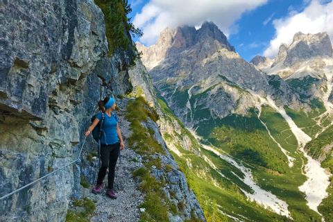 Hiker on the hiking trail through the imposing Brenta Dolomites