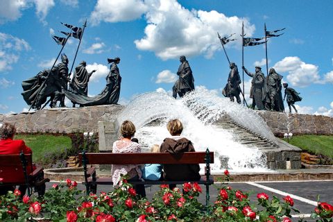 Family on bench look at the Nibelung monument in Tulln