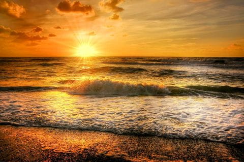 Strand zee ondergaande zon