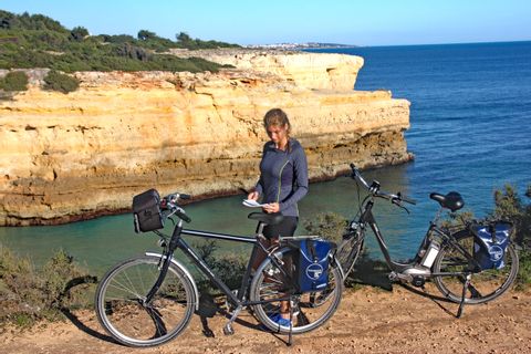 Cyclist and bikes in front of the sea and rocks