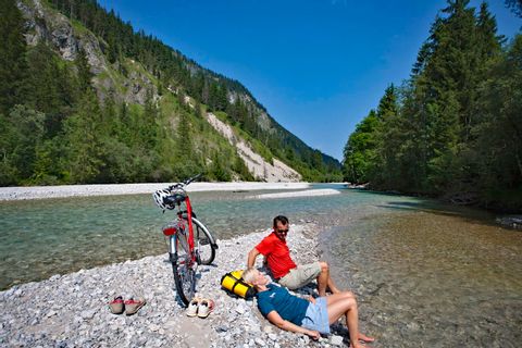 Cyclists having a break on a sandbank in the river Isar