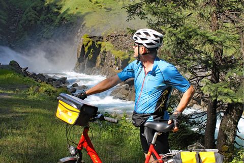 Cyclist in front of waterfalls of Krimml