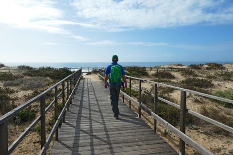 Hiker along the sandy coastline of the Algarve region