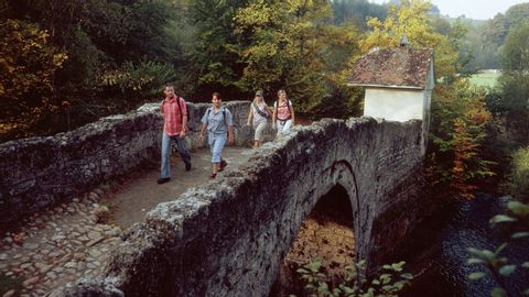 Group crosses an old stone bridge